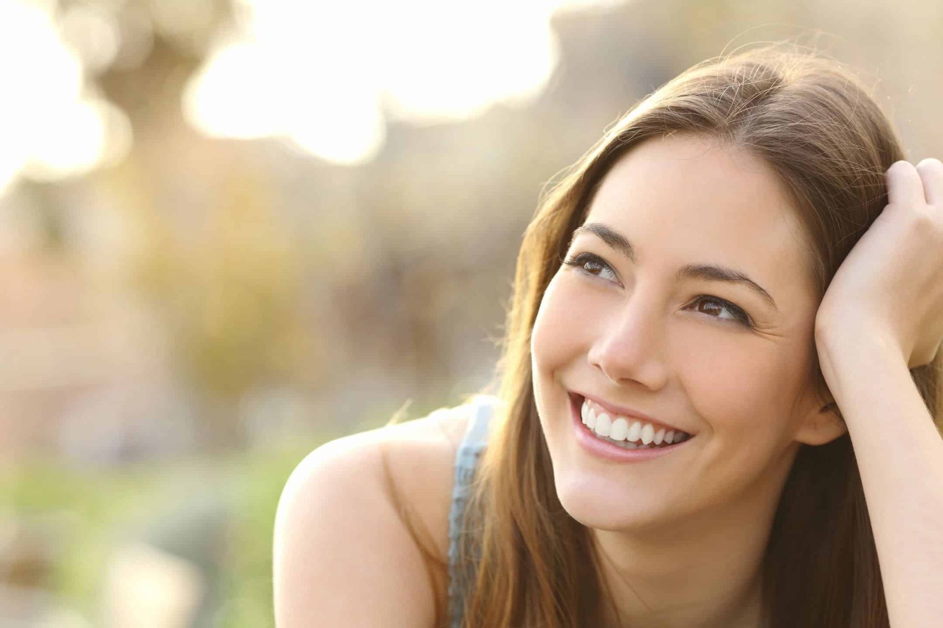 Tranquil woman smiling outdoors, reflecting wellness, happiness, and mental health.