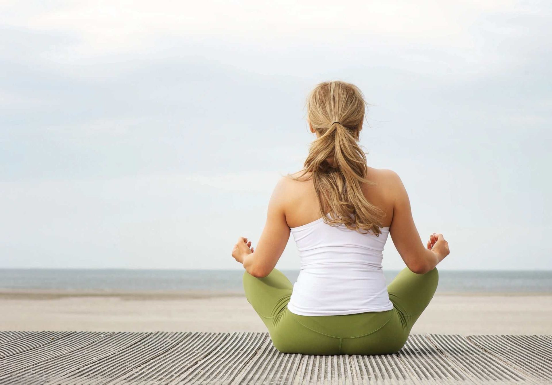 Yoga or meditation on the beach for wellness and relaxation.